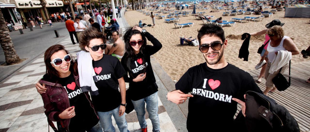 Un grupo de jóvenes turistas portugues con una camiseta de recuerdo de Benidorm en el Paseo de Levante