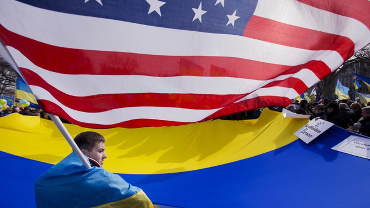 Un joven ucraniano, entre la bandera de Ucrania y la de EEUU, en una manifestación contra Rusia frente a la Casa Blanca, el jueves.