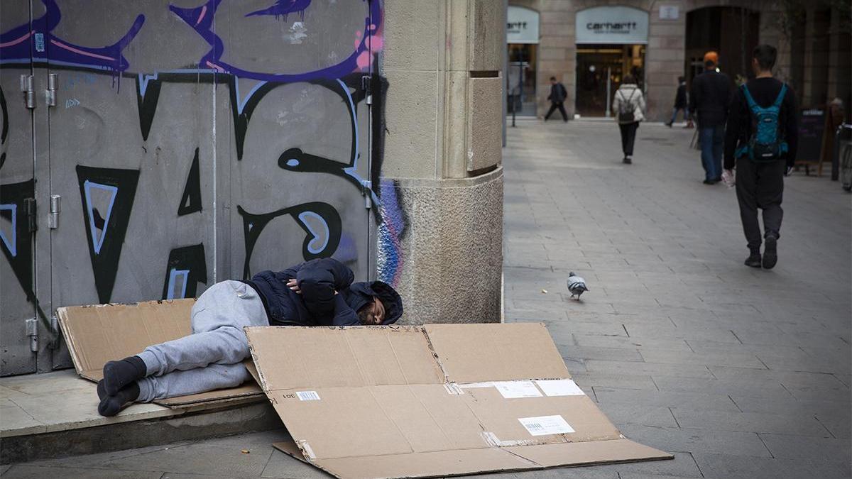 Un 'sin techo' duerme en la calle.