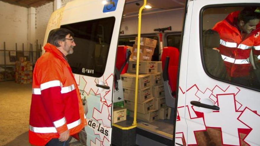 Varios voluntarios de Cruz Roja descargan las cajas de comida ayer por la mañana.