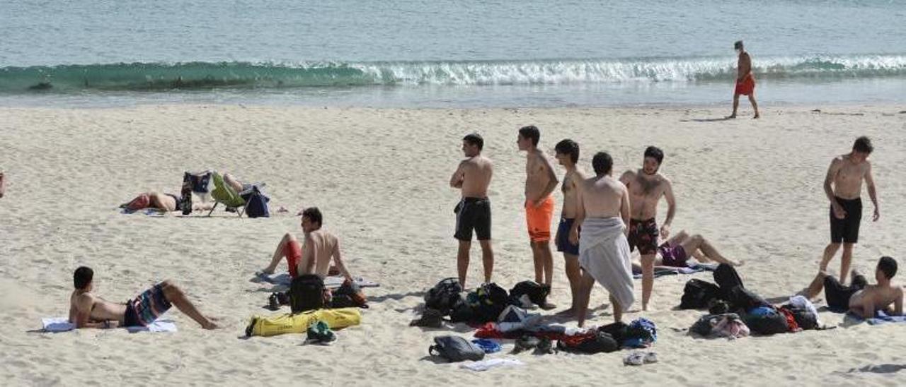 Un grupo de jóvenes
ayer en la playa de Silgar,
en Sanxenxo. |   // RAFA VÁZQUEZ