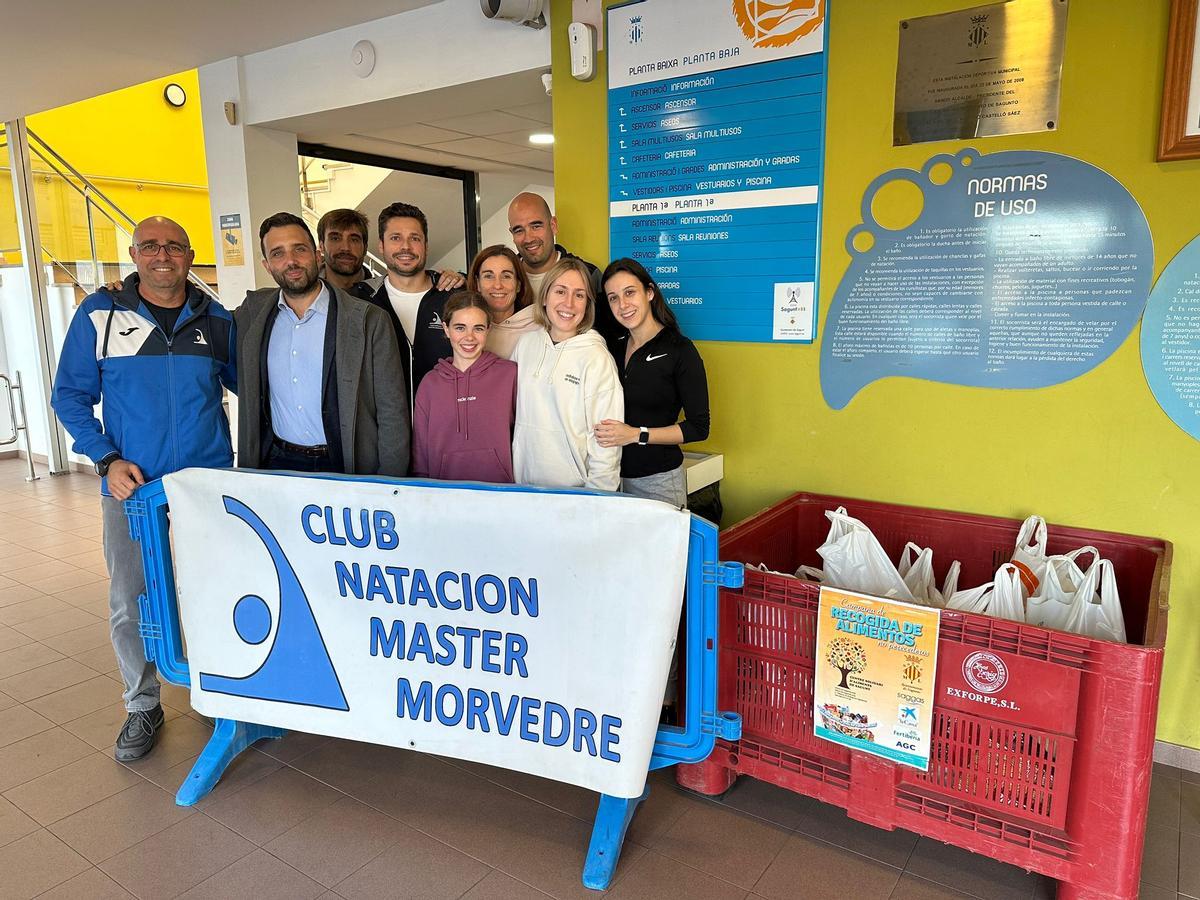 El alcalde de Sagunt, Darío Moreno, y miembros del CN Máster Morvedre junto a los alimentos recogidos.