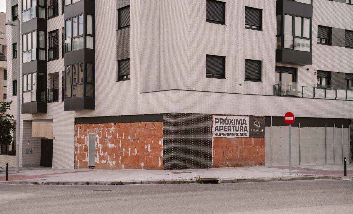Un cartel anuncia la próxima apertura del que será el tercer supermercado del barrio.