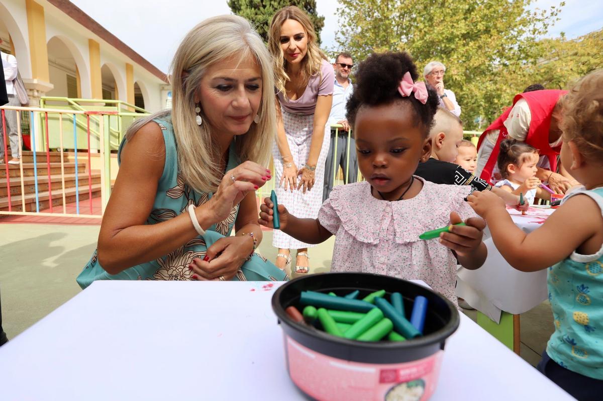 La consejera de Educación juega con una niña en la escuela infantil Azahara en el inicio del curso escolar 2023-2024