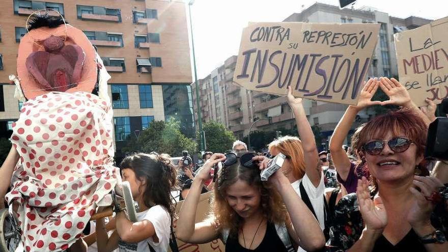 Varias mujeres, ayer ante el juzgado, portando la polémica imagen que salió en procesión en 2014. // Efe