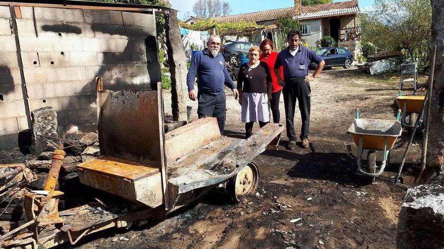 Gonzalo, primero por la izquierda, y José, ante un cobertizo quemado en Pesqueiras (Salvaterra). // D.P.