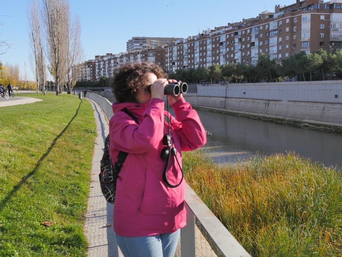 Una mujer observa aves en Madrid.