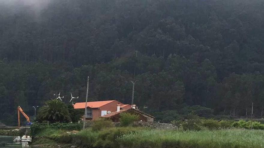 El puerto de Bustio, con la máquina encargada del dragado parada al fondo, ayer.