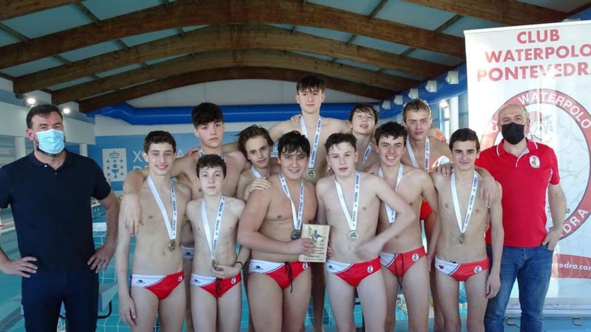 El equipo infantil con el trofeo y las medallas de campeón. |  // FDV