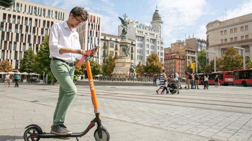 Un joven, con un patinete en la plaza de España de Zaragoza