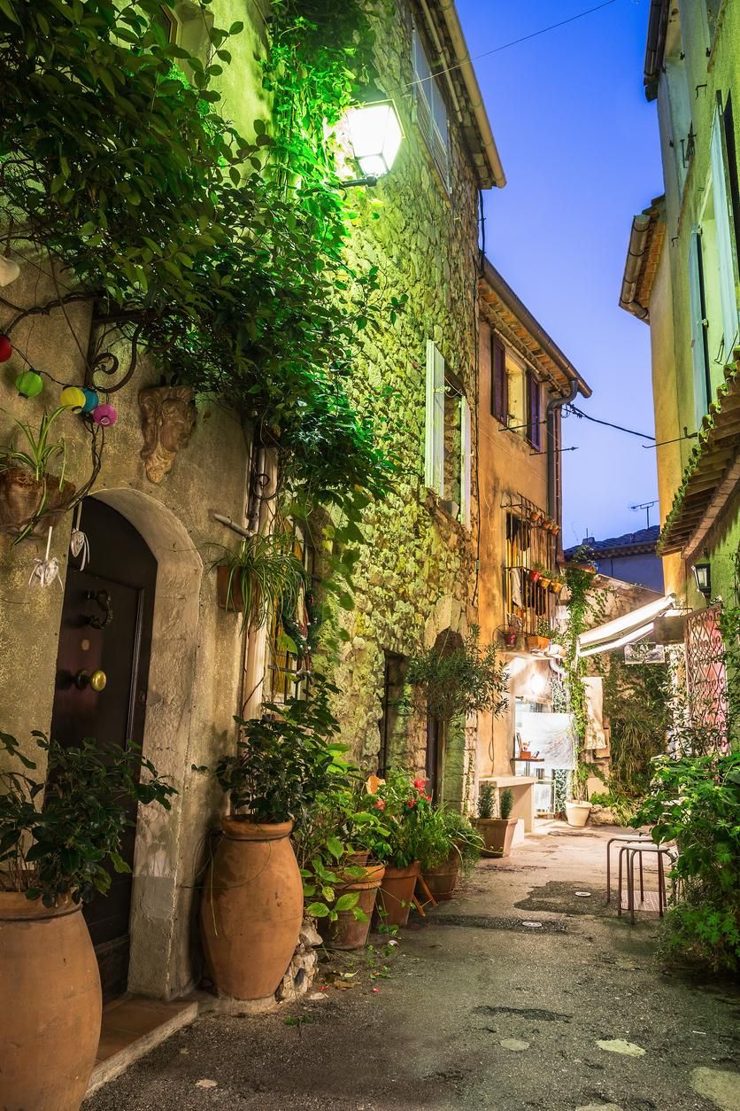 Calle estrecha con flores en el casco antiguo de Mougins en Francia.