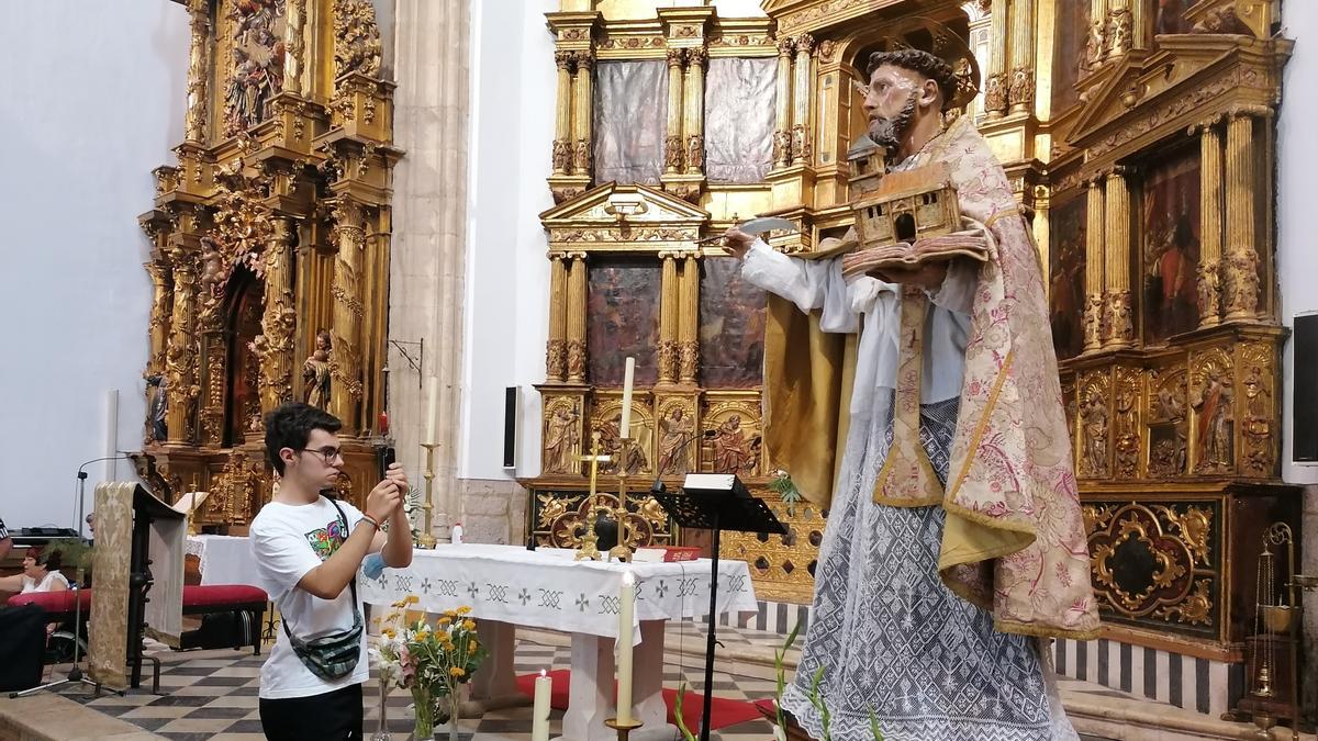 Un joven captura una fotografía de la imagen del santo tras la misa de fiesta