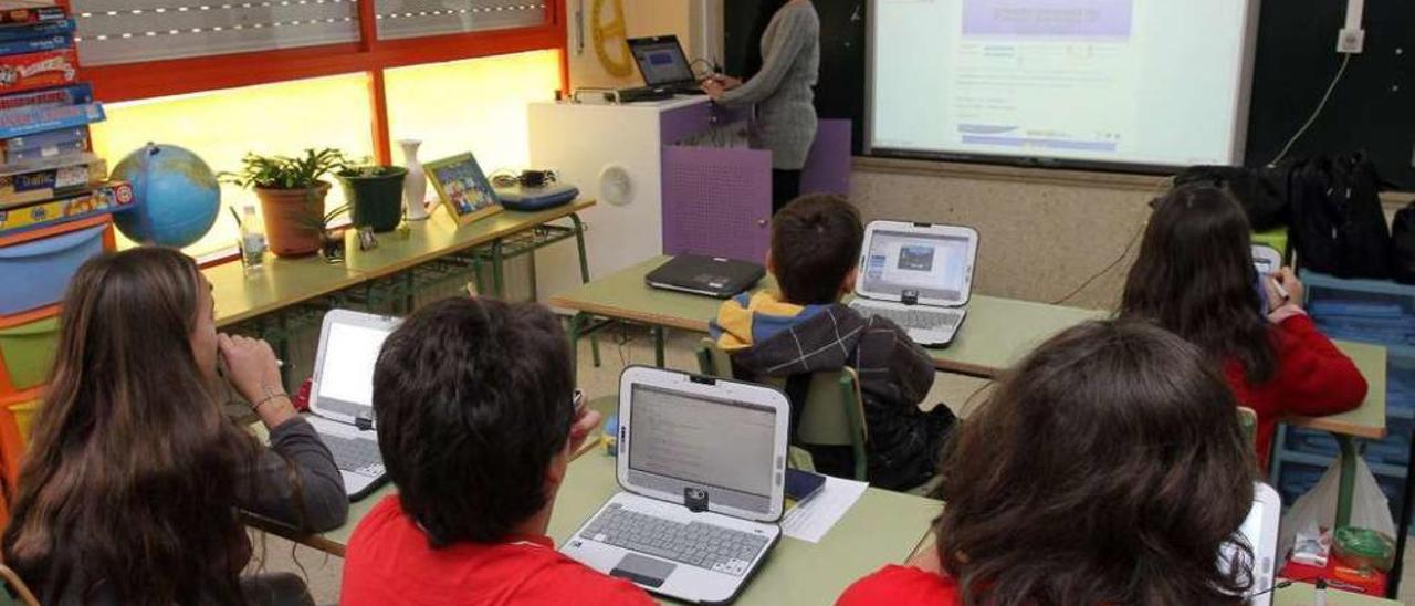 Niños del CPI da Ribeira, en O Porriño, usan ordenadores portátiles en una clase. // Joel Martínez