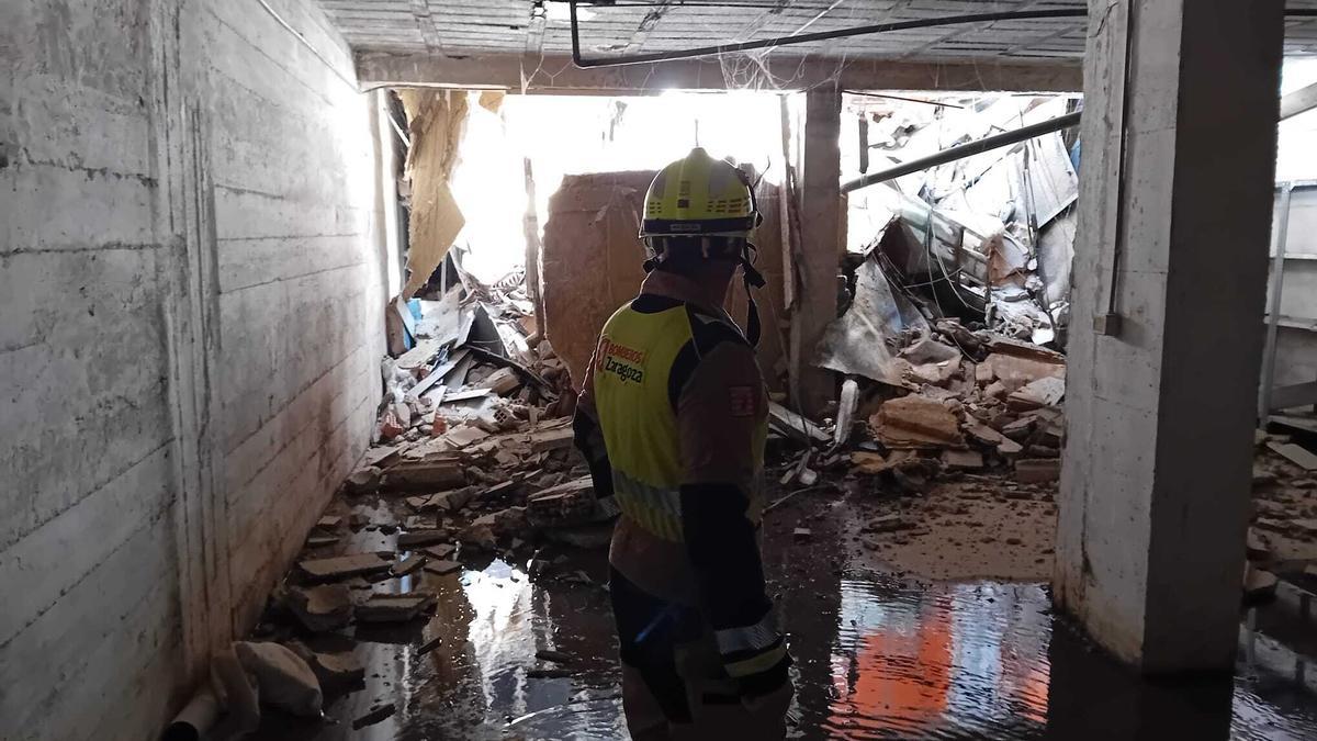 Un bombero, en el local que se derrumbó en un bloque de viviendas en Zaragoza el pasado sábado.