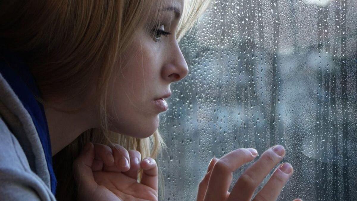 Una mujer mirando por la ventana.