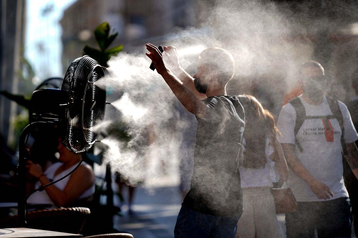 Un joven se refresca con un ventilador situado en el centro de Madrid durante un episodio de ola de calor.