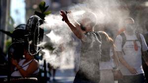 Un joven se refresca con un ventilador situado en el centro de Madrid durante un episodio de ola de calor.