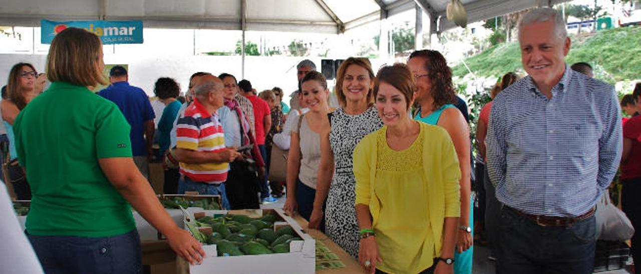 La alcaldesa de Mogán, Onalia Bueno (de amarillo), visita uno de los puestos junto a la consejera insular y otros políticos.