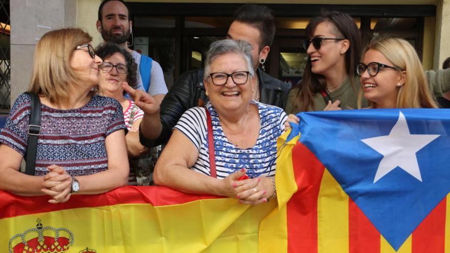 Dues dones que porten una bandera espanyola amb uns nois que porten una estelada