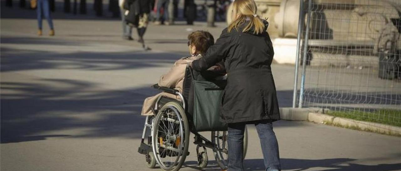 Una persona mayor dependiente en silla de ruedas.
