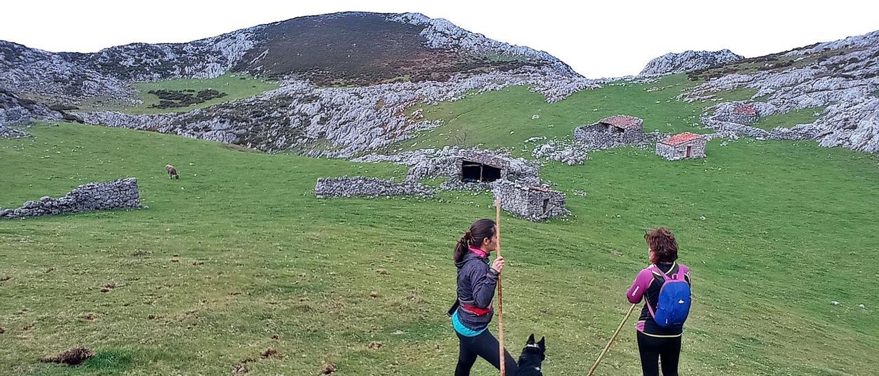 Excursionistas frente a varias cabañas en Arnaedu, Onís. | Eva San Román