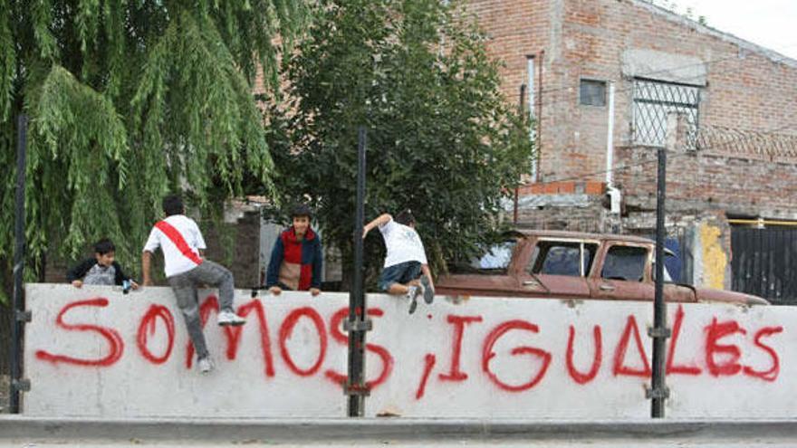 Niños de un barrio de la periferia de la ciudad de Buenos Aires (Argentina), saltan por encima de un muro que se construye para separar una lujosa zona residencial de la localidad de San Isidro con su vecina de San Fernando hoy, 8 de abril de 2009. El alcalde del municipio de San Isidro, Gustavo Posse, ratificó su intención de levantar un paredón de más de 1,5 kilómetros de extensión pese a que las autoridades de la provincia de Buenos Aires dijeron que se lo impedirán y de la oleada de críticas que recibió.