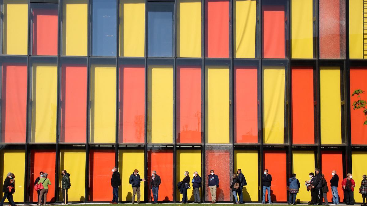 Un grupo de personas espera para recibir la vacuna en el Palacio de Exposiciones de León.