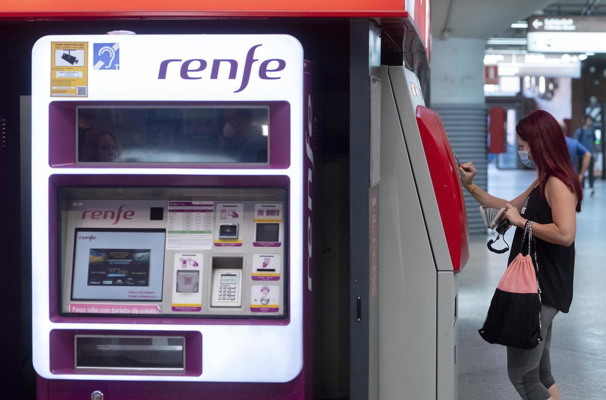 Archivo - Una mujer compra su billete en las taquillas de venta automática de la estación de tren de Atocha, a 1 de septiembre de 2022, en Madrid (España).
