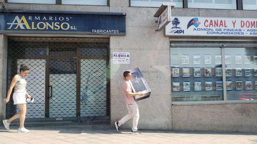Un hombre lleva un ventilador por la acera de una de las calles de la ciudad. | // FERNANDO CASANOVA