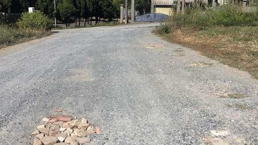 Baches, uno cubierto con piedras y escombros, en el acceso a uno de los aparcamientos desde la calle Castros de Toiriz.