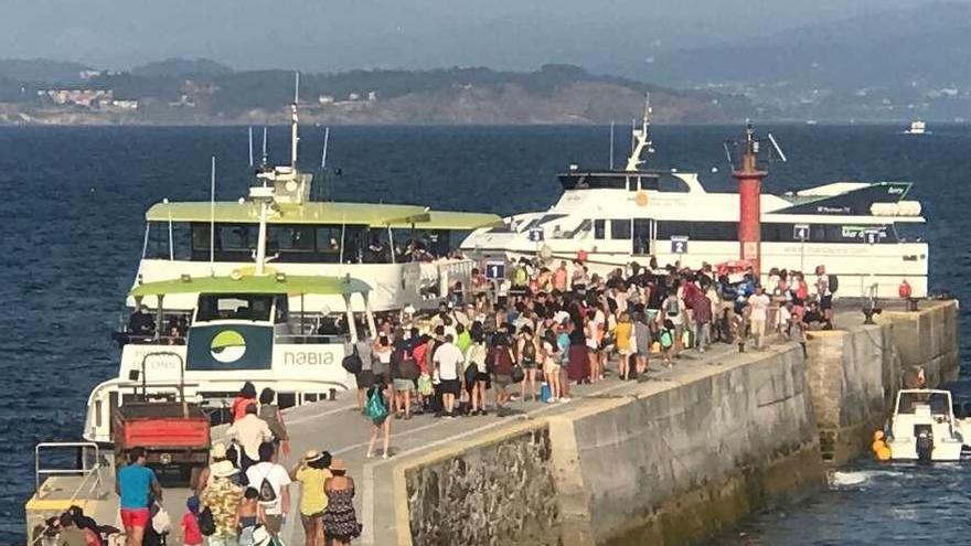 El muelle de Ons lleno de visitantes, ayer, para volver a coger el barco de regreso. // FdV