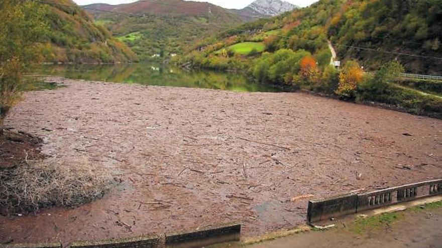 El pantano de Tanes, con suciedad acumulada en el antiguo puente de Coballes, el pasado martes.