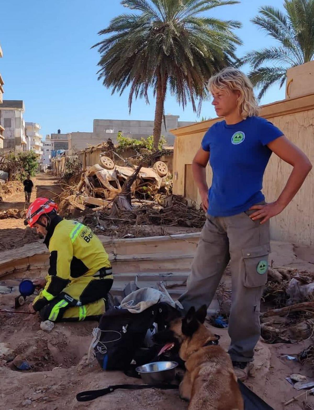 Elena Marcos, con «Mini», Rubén Rocandio seguido por «Kenia», y los destrozos. | Unidad Canina de Rescate