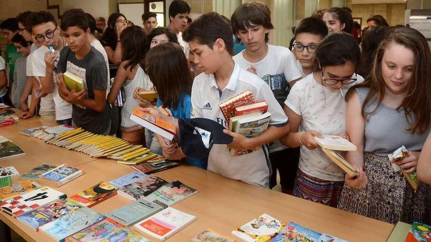 Varios chavales escogen libros de una de las mesas dispuestas en el instituto. // Rafa Vázquez