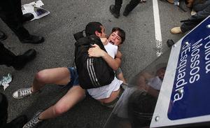 Una parella es protegeix a terra dels possibles cops dels Mossos d’Esquadra que han intentat desallotjar la plaça de Catalunya aquest divendres.