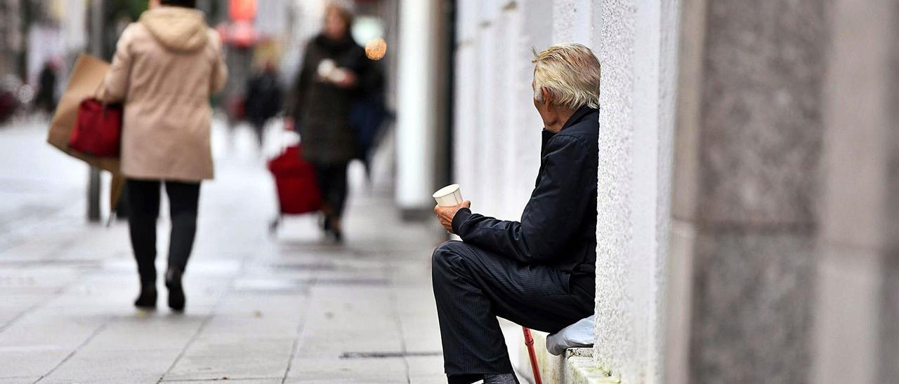 Un hombre pide ayuda económica en una calle de Pontevedra. |   // GUSTAVO SANTOS