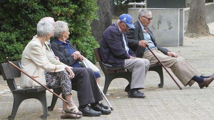 Un grupo de personas mayores sentadas en unos bancos en la ciudad de Ourense. // Iñaki Osorio