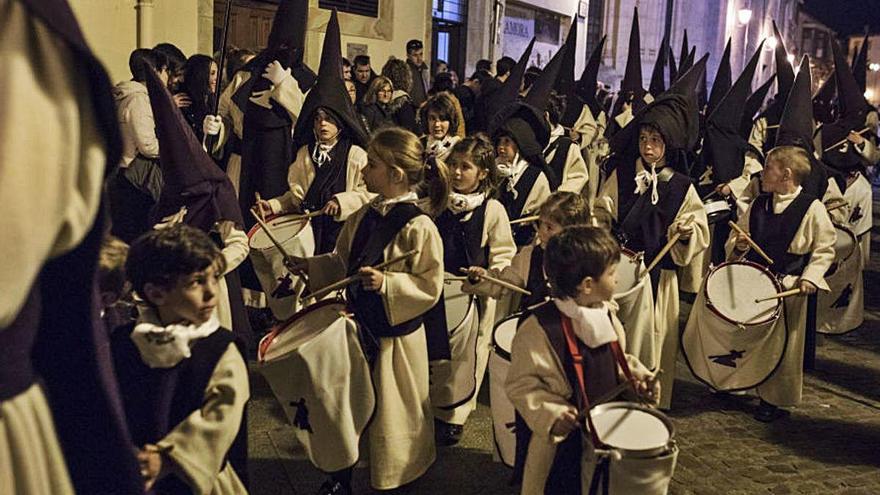 Niños y niñas tocan los tambores en la procesión de Jesús del Vía Crucis.