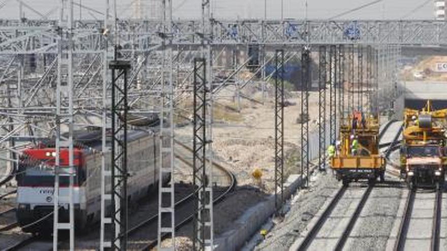 Dos máquinas trabajan en los carriles junto al túnel donde finaliza el soterramiento y las vías salen a la superficie hacia la Estación de Alta Velocidad