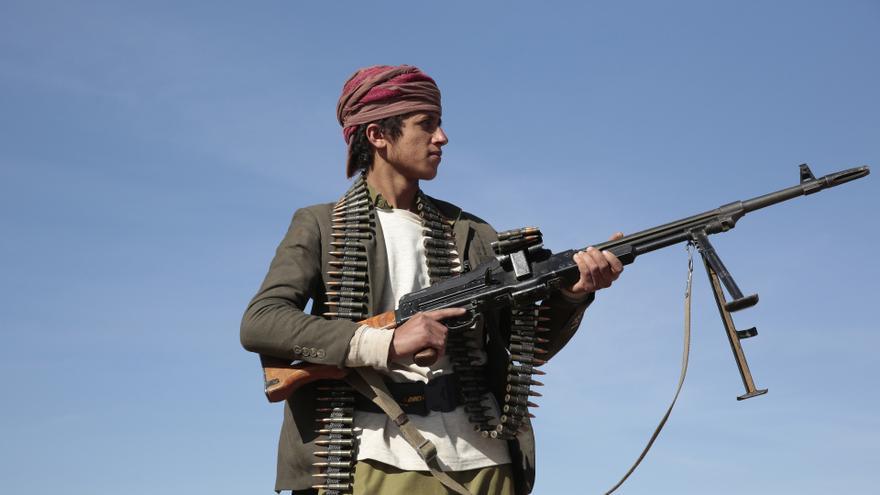 Un  hombre sostiene un arma y se manifiesta en apoyo de los hutíes en Saná, Yemen.