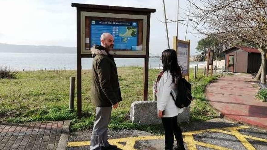 Félix Juncal y Silvia Carballo ante el panel instalado en Area de Bon.