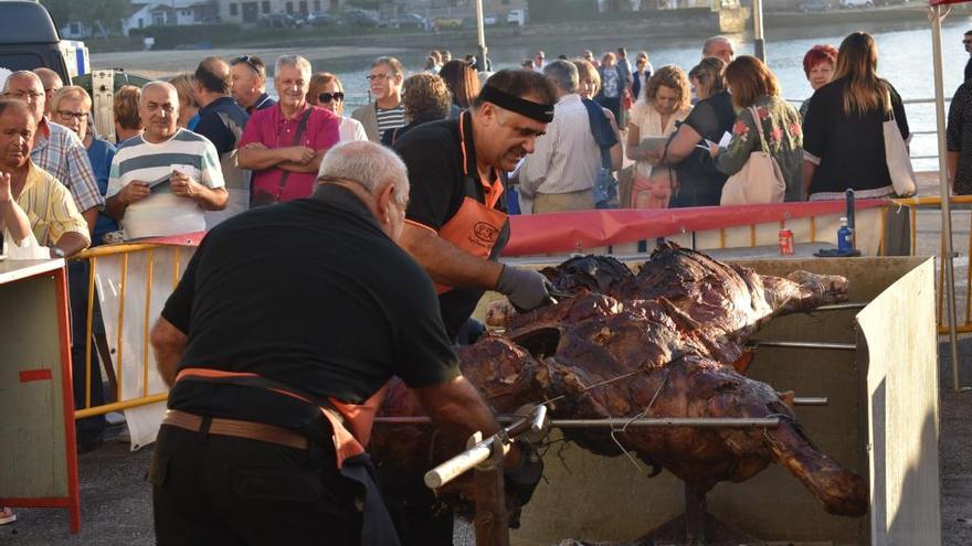 Los cocineros preparan las terneras asadas en la carpa de la fiesta. / A.P.