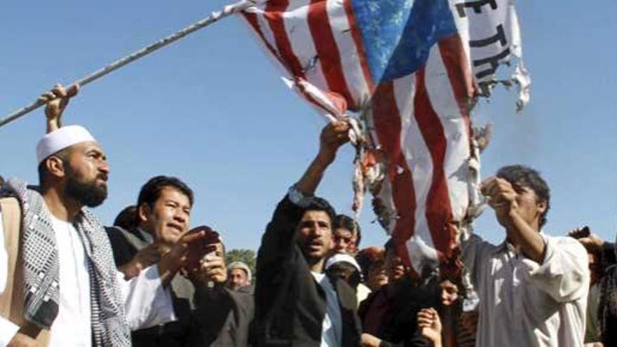 Ciudadanos afganos queman una bandera de EEUU durante una protesta en contra del pastor estadounidense Terry Jones en Herat.