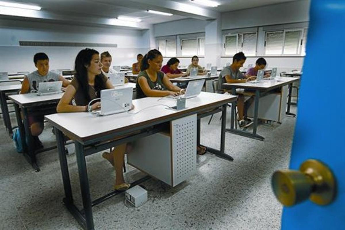 Alumnos de ESO de un instituto de Badajoz trabajan en una clase con ordenadores portátiles.