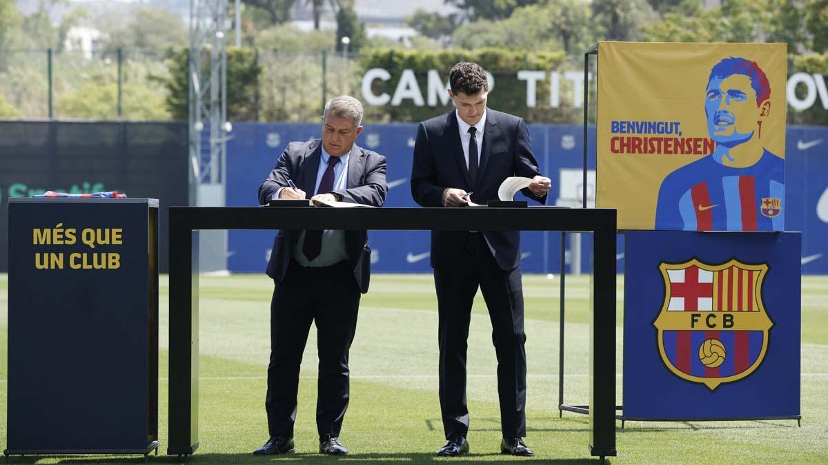 El presidente del FC Barcelona, ​​Joan Laporta, y el nuevo jugador Andreas Christensen firman contratos durante la presentación.