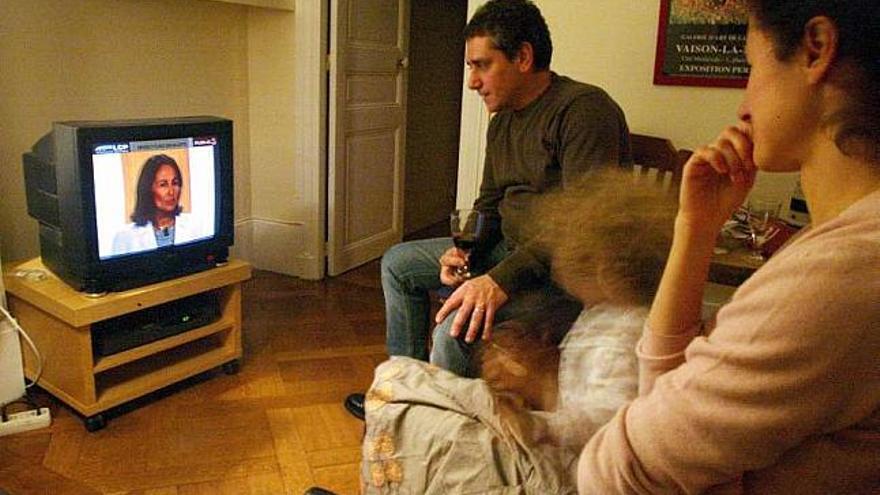 Una pareja ve la televisión en su salón. / efe