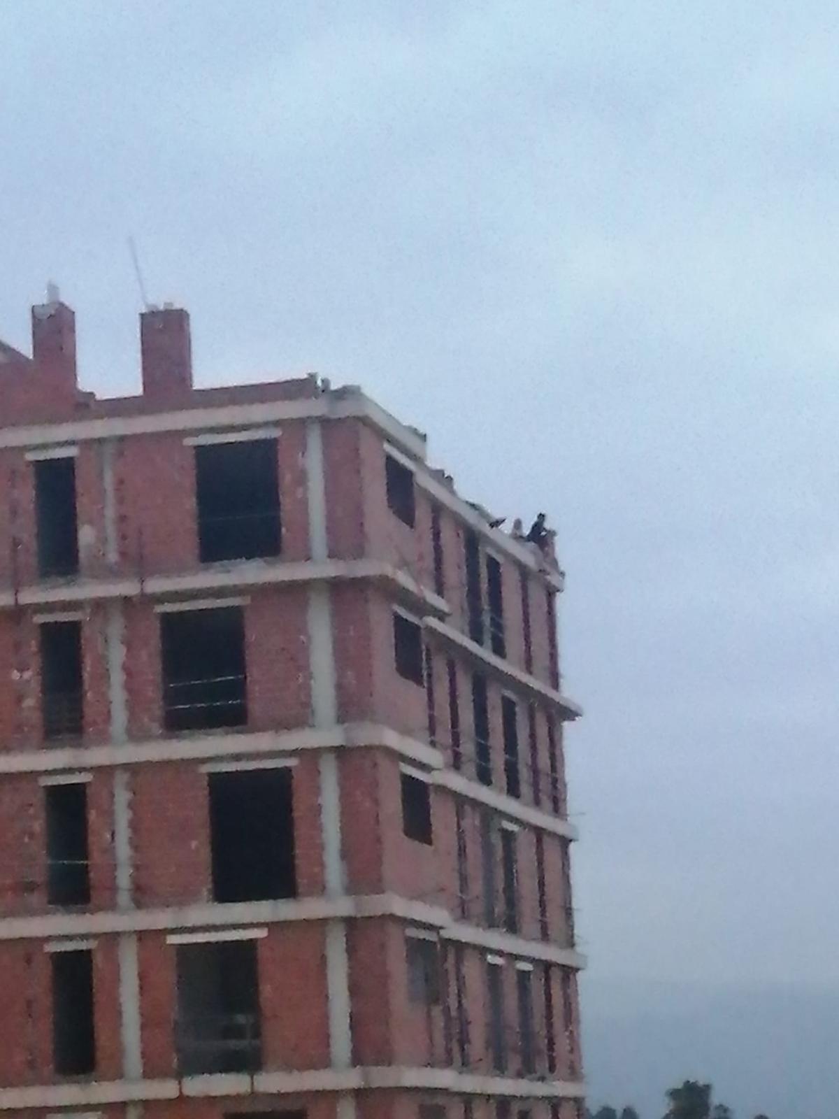 Personas subidas en el techo del edificio.