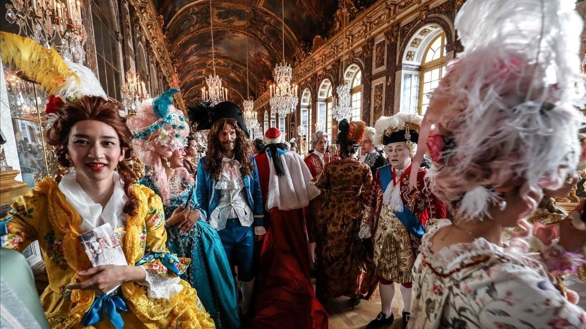 Gente vestida con ropa de época participan en la noche de disfraces de las ’Fetes Galantes’ en la galeria de espejos del Chateau de Versailles