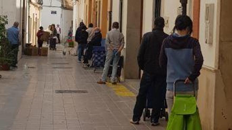 Cola para recibir bolsas con alimentos en el Comedor Social San José de Benimaclet.