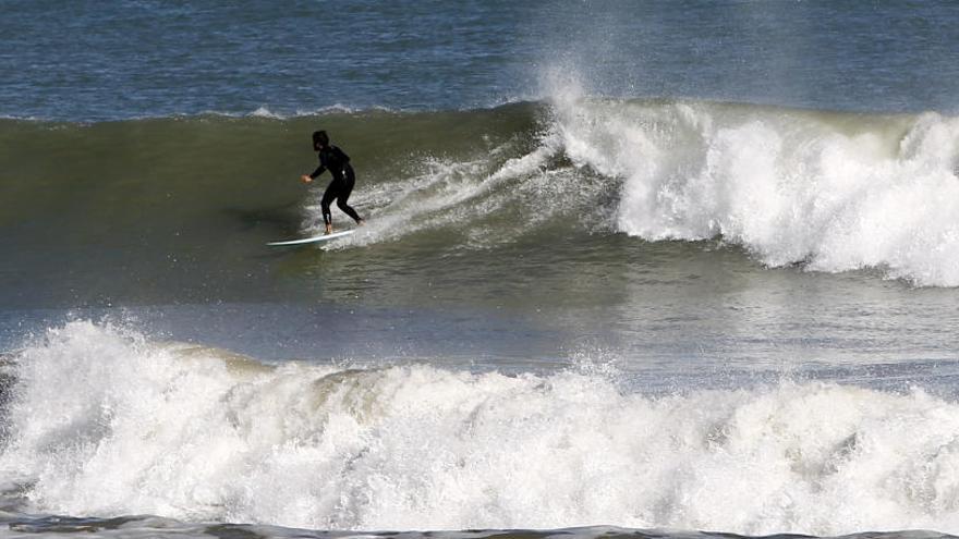 Un surfista coge una ola.